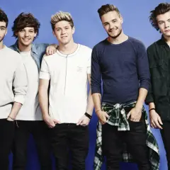 Pięciu członków One Direction pozuje do zdjęcia na niebieskim tle.