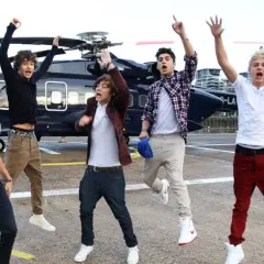 Chłopcy z One Direction skaczą z radości obok helikoptera, jakby właśnie usłyszeli swoje nowe piosenki.