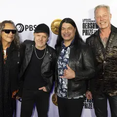 Członkowie zespołu Metallica pozują do zdjęcia. Kirk Hammett, Lars Ulrich, Robert Trujillo i James Hetfield wyglądają elegancko.