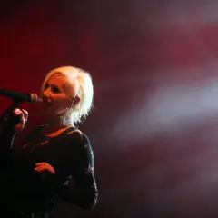 Kora Jackowska śpiewa na scenie, wykonując swoje utwory. Wokół niej unosi się mgła, a czerwone światła tworzą nastrojową atmosferę.