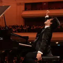 Młody pianista w ekstazie po wykonaniu utworu na scenie. Czy to finał konkursu chopinowskiego, który odbywa się co ile lat?