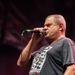 Kultowy wokalista z mikrofonem na scenie. Jego charyzma przyciąga tłumy.