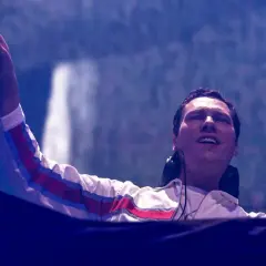 DJ Tiësto w Polsce, z palcem w górze, rozgrzewa tłum.