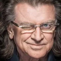 Zbigniew, kompozytor i dyrygent, z charakterystycznym uśmiechem i mrugnięciem, w okularach.