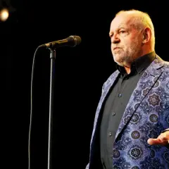 Joe Cocker w swojej charakterystycznej marynarce, gotów zaśpiewać swoje niezapomniane utwory.