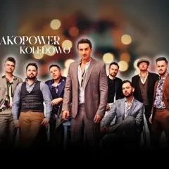 Grupa Zakopower w eleganckich strojach, z wokalistą na pierwszym planie, gotowa do kolędowania.