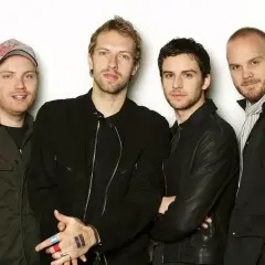 Członkowie Coldplay pozują do zdjęcia. Na dłoni jednego z nich widnieje tatuaż symbolizujący pauzę.