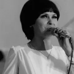 Katarzyna Sobczyk śpiewa do mikrofonu, w białej bluzce z serduszkiem na szyi. Jej życie prywatne to temat, który zawsze budził zainteresowanie.