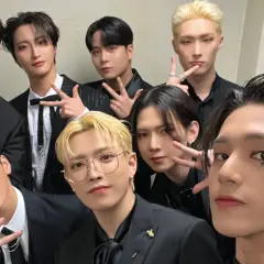 Grupa ATEEZ w czarnych garniturach, gotowa do promocji nowych **ateez albumy**.