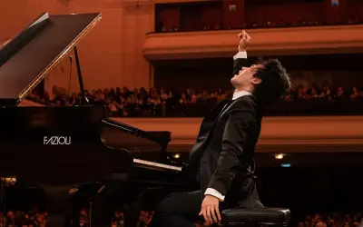 Młody pianista w ekstazie po wykonaniu utworu na scenie. Czy to finał konkursu chopinowskiego, który odbywa się co ile lat?
