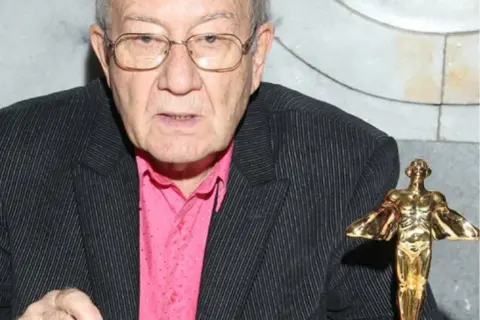 Andrzej Dąbrowski z żoną i dziećmi świętuje sukces, trzymając w dłoni statuetkę.