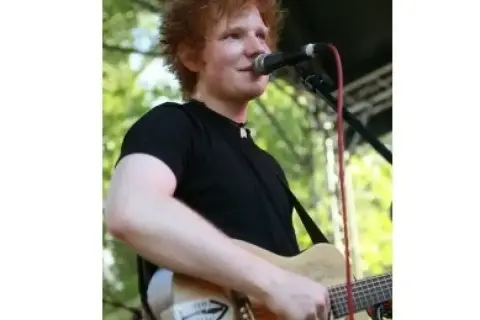 Ed Sheeran gra na gitarze, śpiewając do mikrofonu. Czy Ed Sheeran ma dzieci? Tak, jest ojcem dwójki.