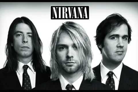 Trzech członków zespołu Nirvana w garniturach: Kurt Cobain, Dave Grohl i Krist Novoselic.