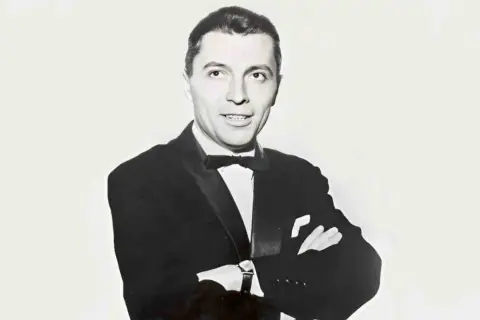 Elegancki Janusz Budzyński, mąż Alicji Majewskiej, w czarnym smokingu z muszką.