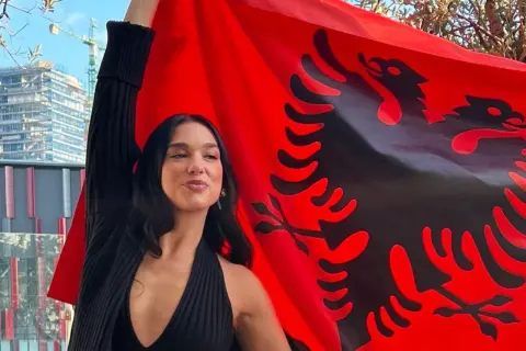 Dua Lipa z dumą prezentuje albańską flagę, podkreślając swoje dua lipa pochodzenie.