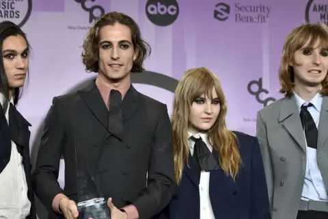 Måneskin członkowie pozują z nagrodą American Music Awards.