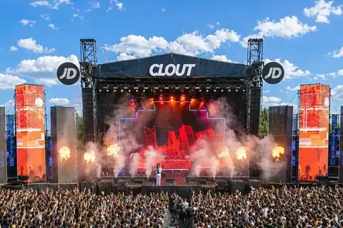 Scena festiwalowa Clout z artystą i tłumem widzów, w tle niebo z chmurami.