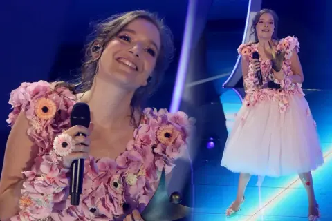 Zuzanna Jurczak, znana jako piosenkarka, w kwiecistej sukni na scenie.