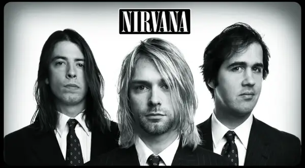 Trzech członków zespołu Nirvana w garniturach: Kurt Cobain, Dave Grohl i Krist Novoselic.
