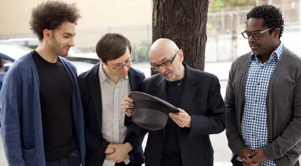 Tomasz Trebacz i kompozytor jazzowy, z kolegami, dyskutują o kapeluszu.
