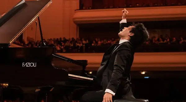 Młody pianista w ekstazie po wykonaniu utworu na scenie. Czy to finał konkursu chopinowskiego, który odbywa się co ile lat?