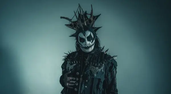 Postać w makijażu przypominającym czaszkę, z kolcami i łańcuchami, idealna do **death metal**owej sesji.