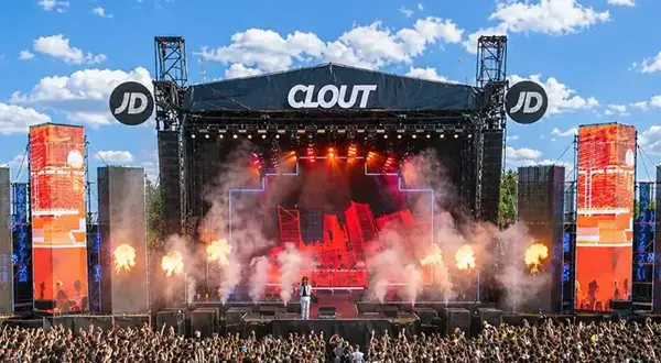 Scena festiwalowa Clout z artystą i tłumem widzów, w tle niebo z chmurami.