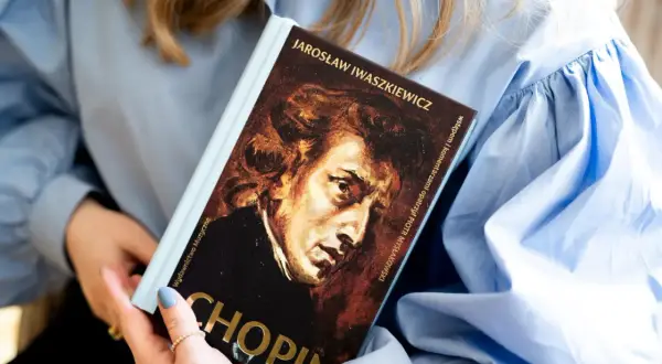 Książka o Chopinie, jednym z najwybitniejszych polskich kompozytorów, w rękach kobiety.