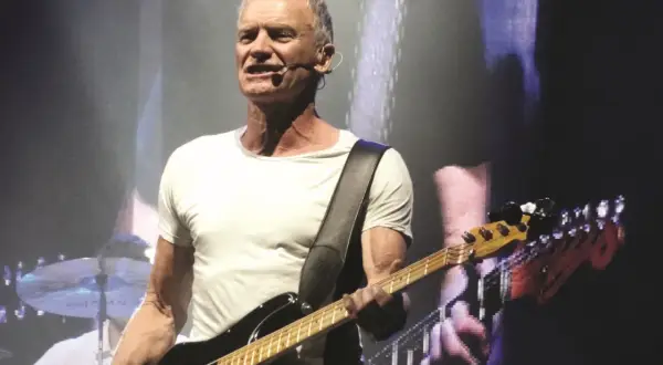 Sting gra na gitarze basowej, wykonując swoje niezapomniane utwory.