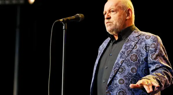Joe Cocker w swojej charakterystycznej marynarce, gotów zaśpiewać swoje niezapomniane utwory.