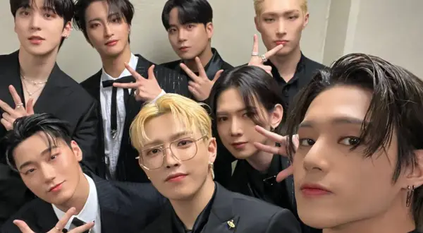 Grupa ATEEZ w czarnych garniturach, gotowa do promocji nowych **ateez albumy**.