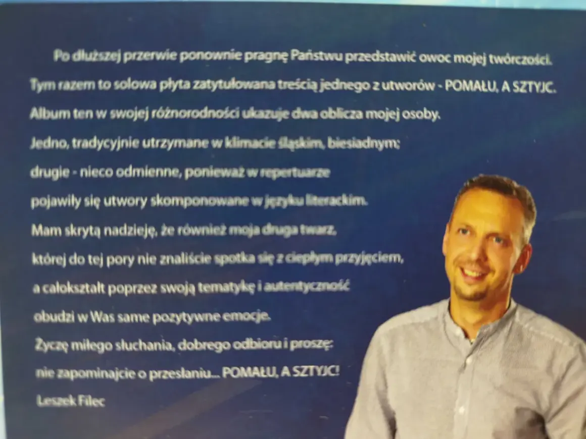 Portret Leszka Fileca, uśmiechniętego mężczyzny w koszuli, na tle tekstu.