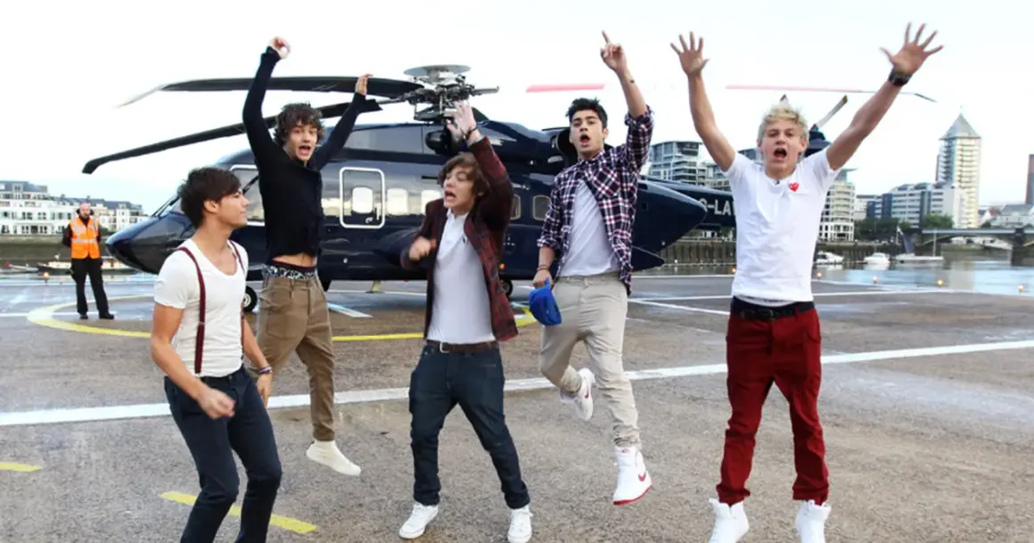 Chłopcy z One Direction skaczą z radości obok helikoptera, jakby właśnie usłyszeli swoje nowe piosenki.