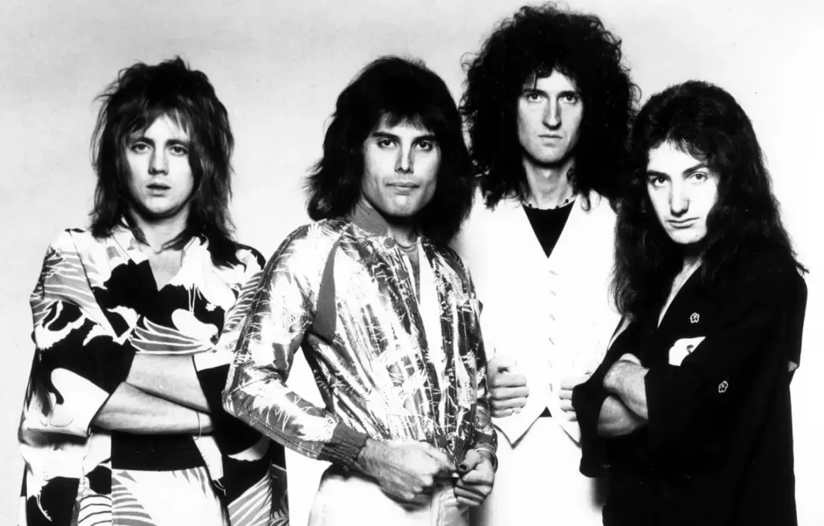 Czterech członków zespołu Queen, w tym Freddie Mercury, w stylizacjach z lat 70. Ich piosenki to ponadczasowe hity.