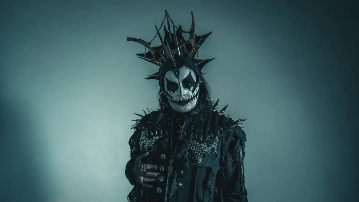 Postać w makijażu przypominającym czaszkę, z kolcami i łańcuchami, idealna do **death metal**owej sesji.