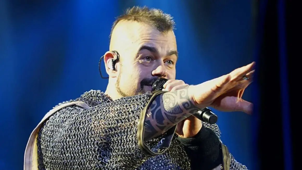 Wokalista Sabaton w kolczudze, z tatuażem na ręce, śpiewa na koncercie. Jego albumy to historie wojenne.