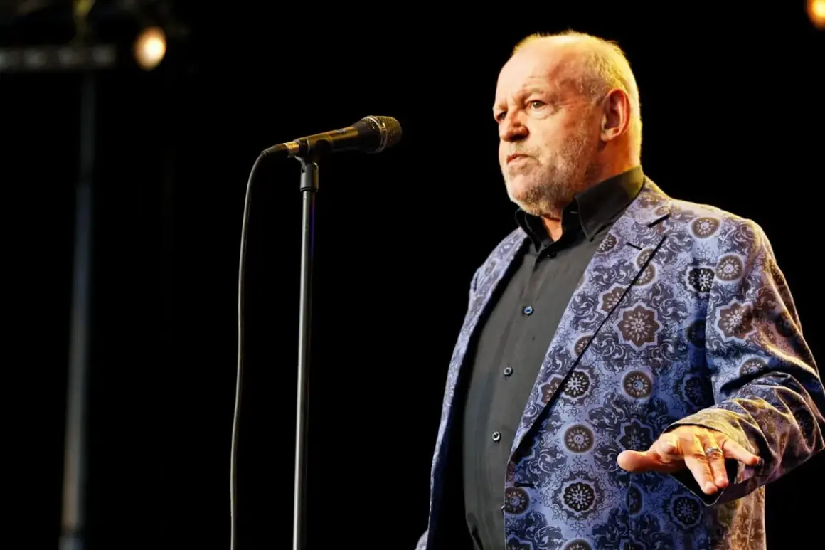 Joe Cocker w swojej charakterystycznej marynarce, gotów zaśpiewać swoje niezapomniane utwory.