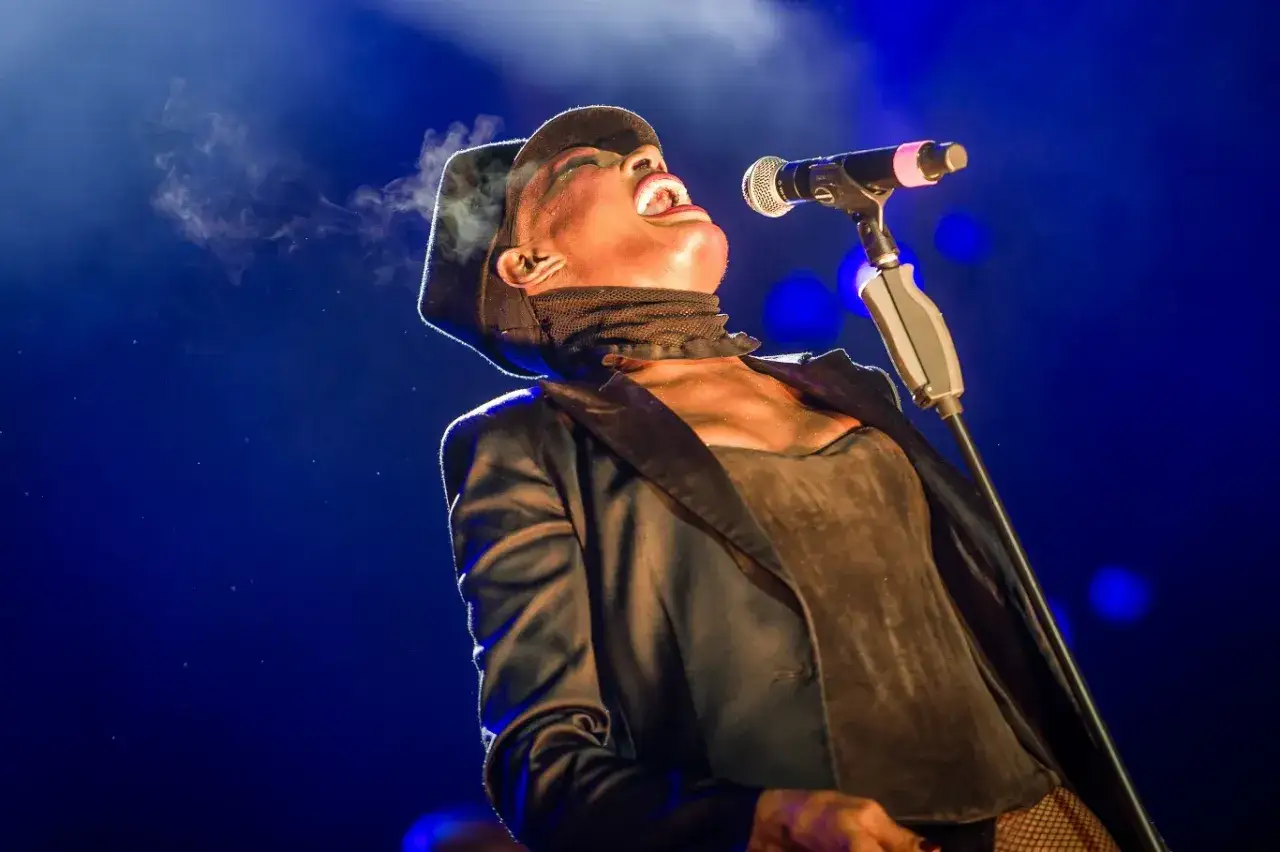 Ikona muzyki pop, wykonawca z charakterystycznym kapeluszem, śpiewa z pasją. Para unosi się z ust, podkreślając emocje.
