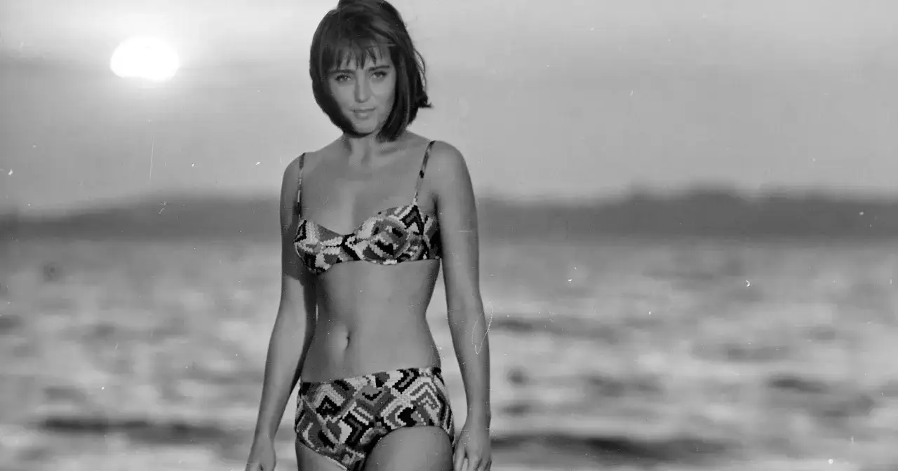 Maja Wodecka, w bikini, na plaży. Słońce zachodzi nad wodą.