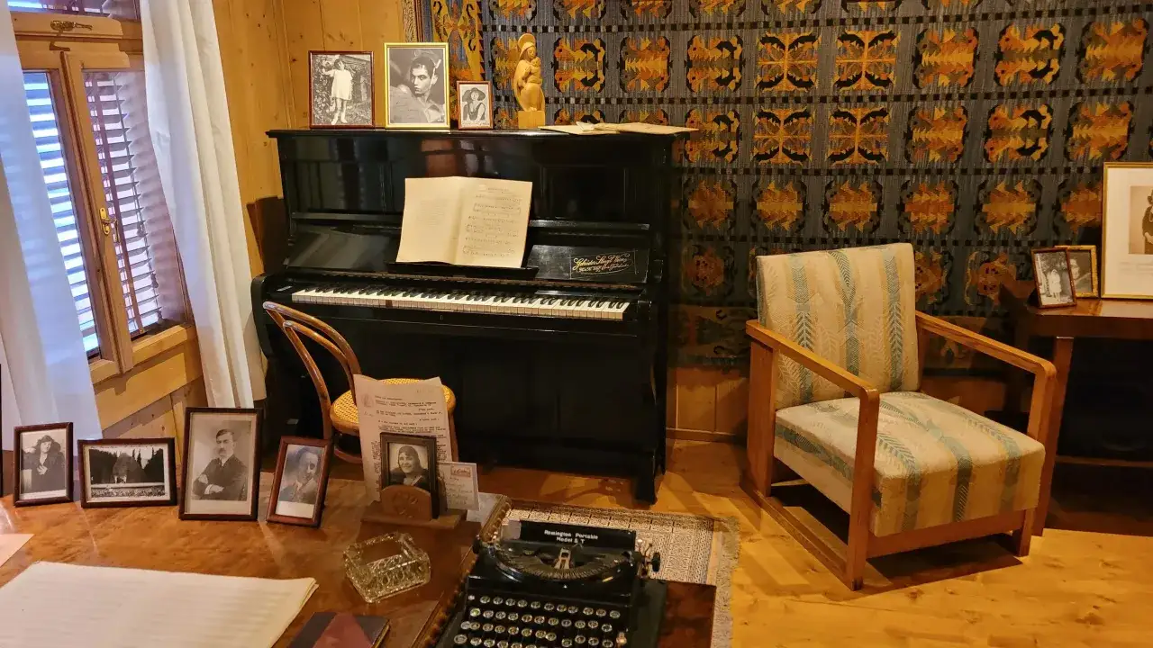 Gabinet kompozytora z fortepianem, maszyną do pisania i portretami. Ciekawostki o Karolu Szymanowskim mogą dotyczyć jego inspiracji i życia.
