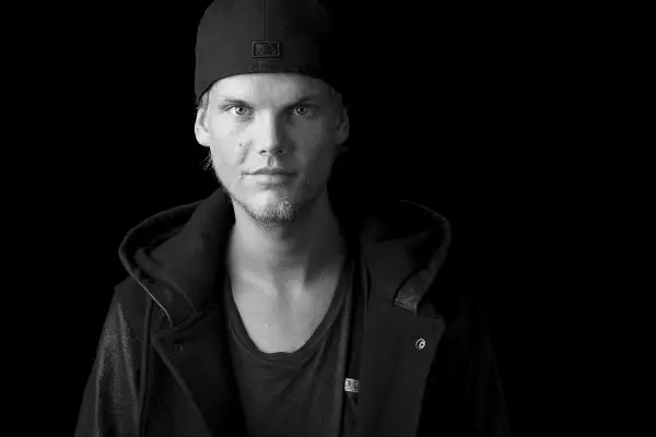 Avicii w czapce z daszkiem i kurtce, z charakterystycznym spojrzeniem.
