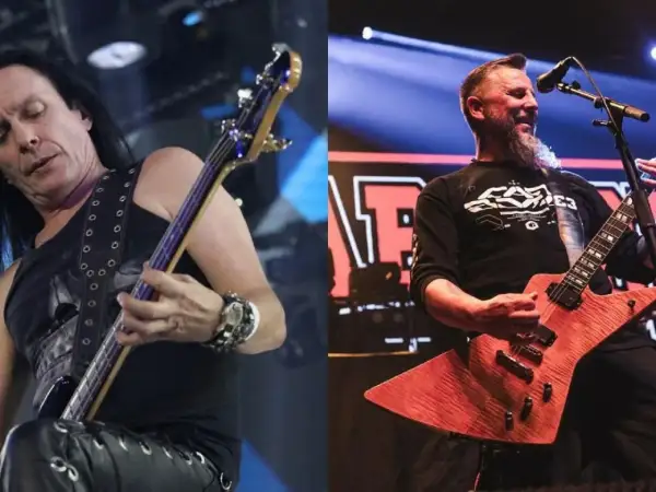 Dwóch członków Acid Drinkers na scenie: basista z długimi włosami i gitarzysta z brodą.