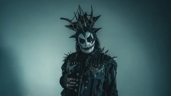 Postać w makijażu przypominającym czaszkę, z kolcami i łańcuchami, idealna do **death metal**owej sesji.