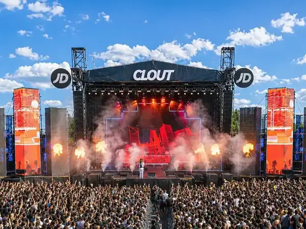 Scena festiwalowa Clout z artystą i tłumem widzów, w tle niebo z chmurami.