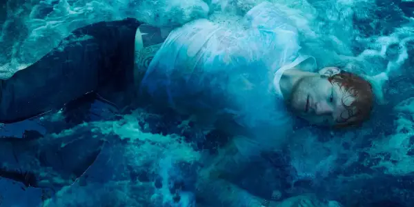 Ed Sheeran zanurzony w wodzie, jak na okładkach jego albumów. Woda tworzy surrealistyczną, błękitną mgłę wokół artysty.