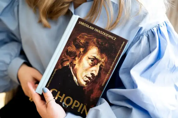 Książka o Chopinie, jednym z najwybitniejszych polskich kompozytorów, w rękach kobiety.